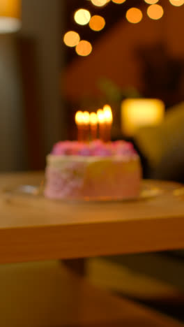 Vertical-Video-Of-Party-Celebration-Cake-For-Birthday-Decorated-With-Icing-And-Candles-On-Table-At-Home-1